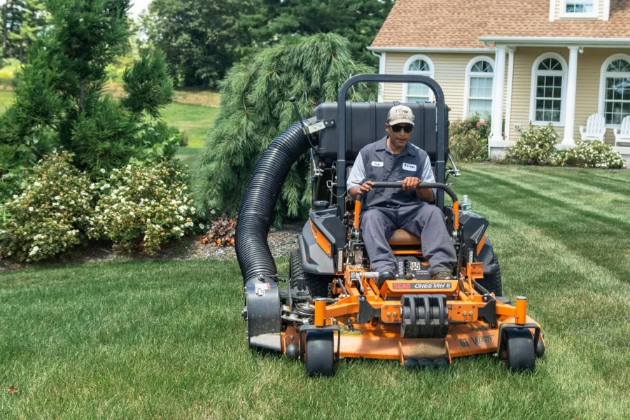 Tynic crew member mowing a striped commercial lawn