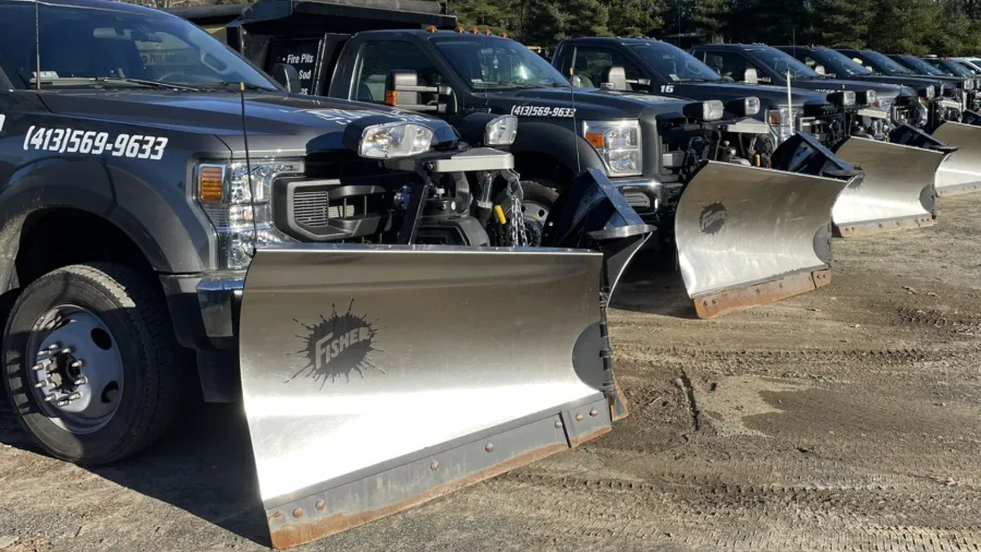 Row of Tynic plow trucks staged for commercial snow removal